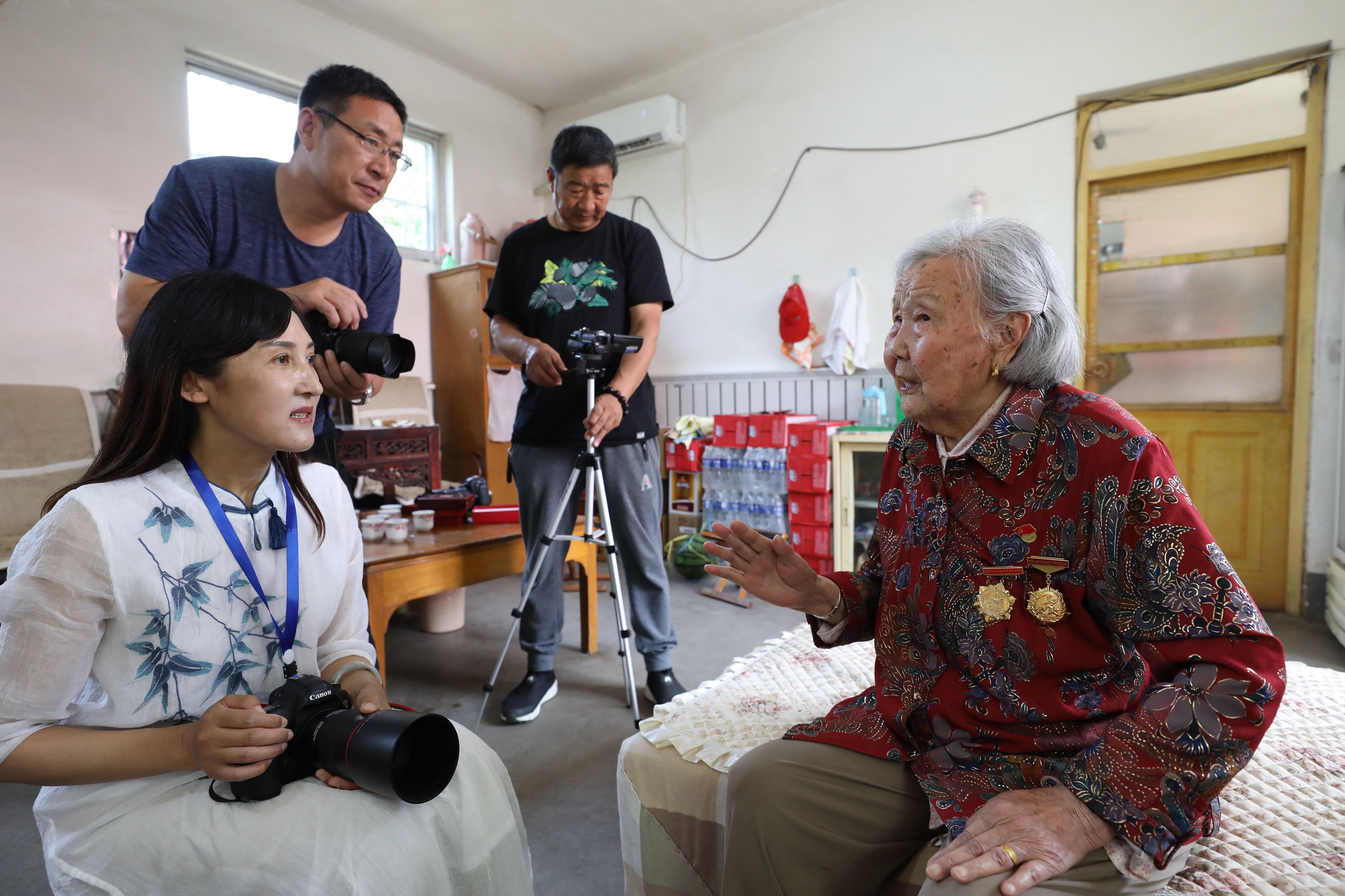 6月4日,在沂南县界湖街道,志愿者在采访拍摄95岁的新中国成立前老党员